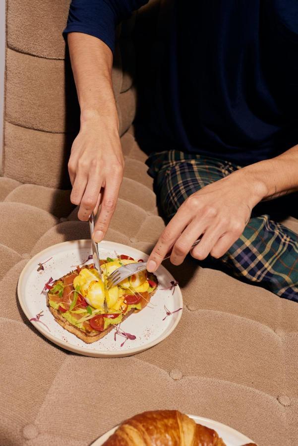 Sanderson Londra Esterno foto A person using a knife and fork to cut food