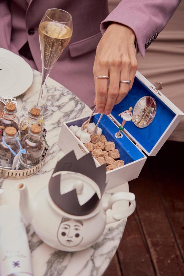 Sanderson Londra Esterno foto A woman using a sugar cube to clean a mirror